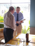 Derek Wood presents Harry Archer with a copy of "Roger So Far", the Corps Centenary book